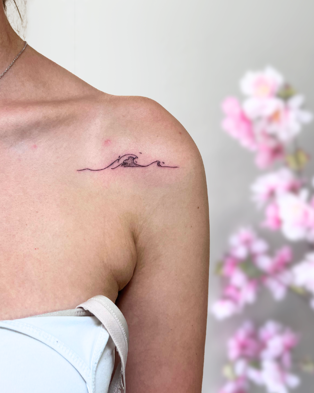 Fine line ocean waves on collarbone