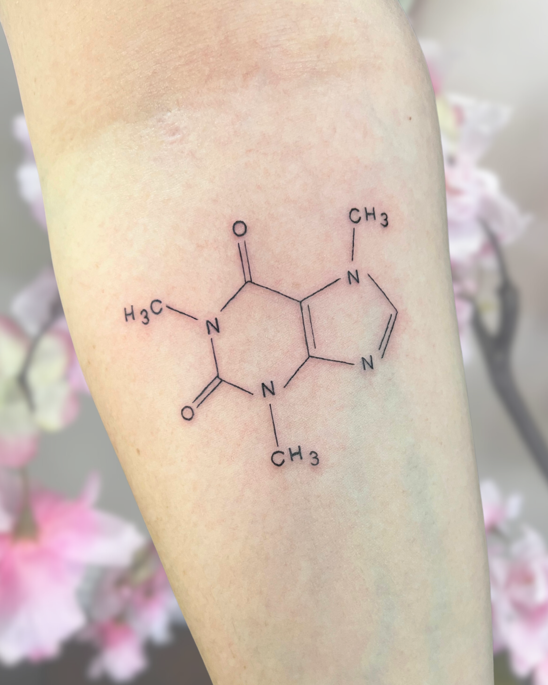 Fine line caffeine molecule on arm